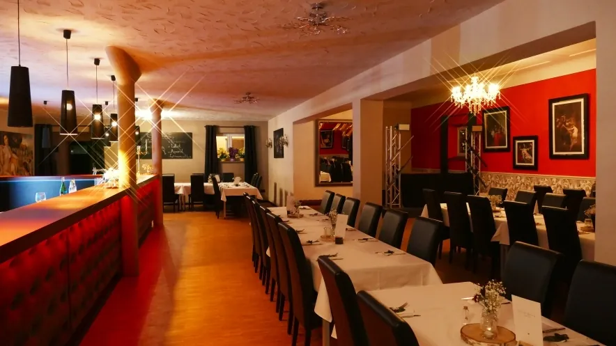 Festlich eingedeckter Veranstaltungsraum mit roter Barockwand
